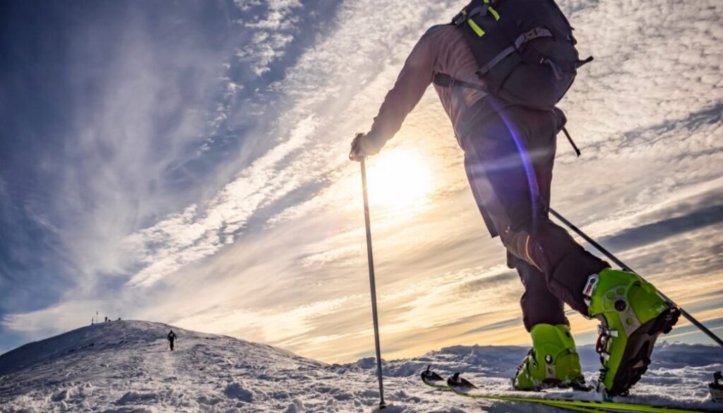 Tourenski leihen: Skitourengeher mit Fellen beim Aufstieg zum Gipfel im Winter